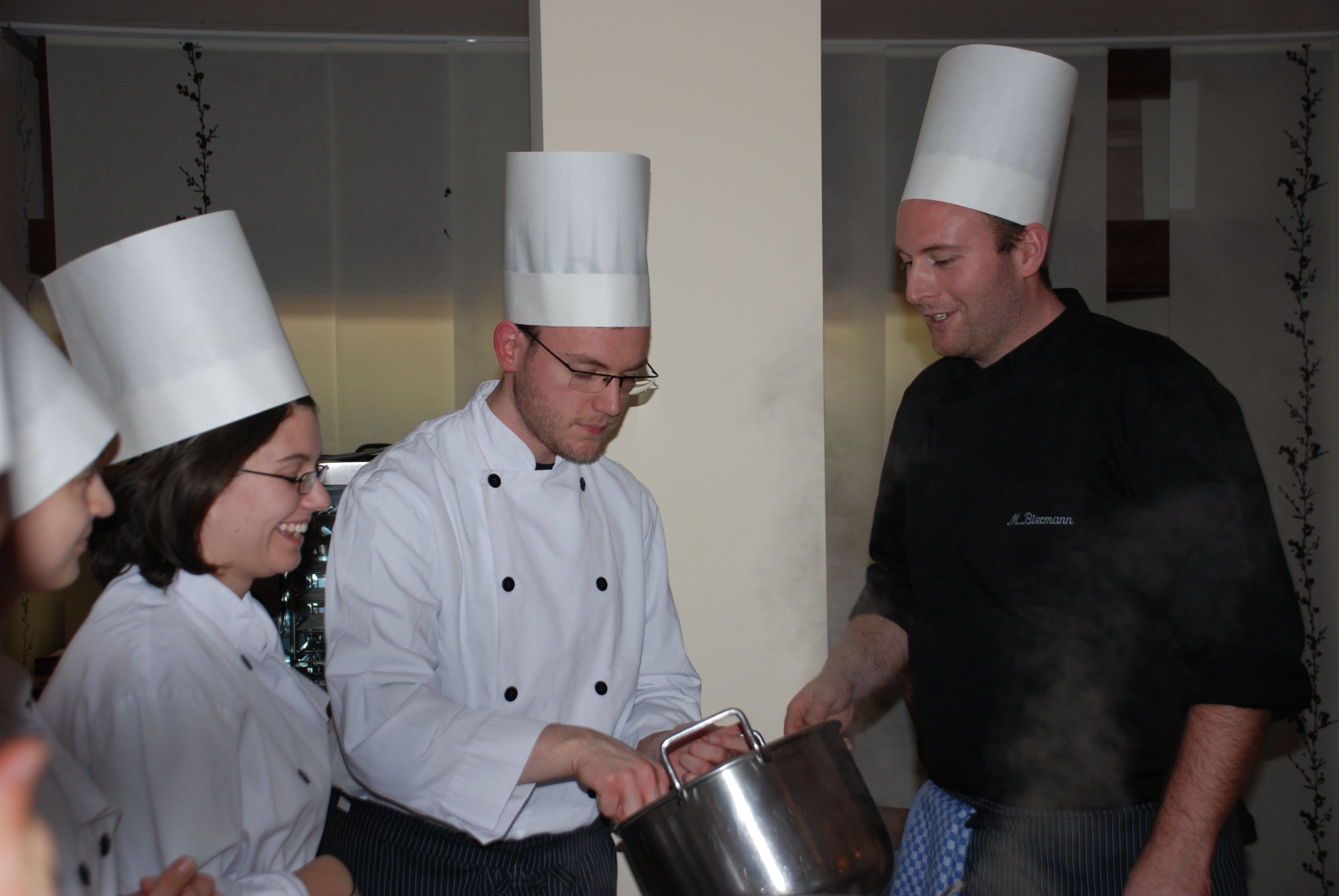 Momentaufnahme beim Kochkurs: Mensakoch erklärt Studierenden die Zubereitung des Essens.