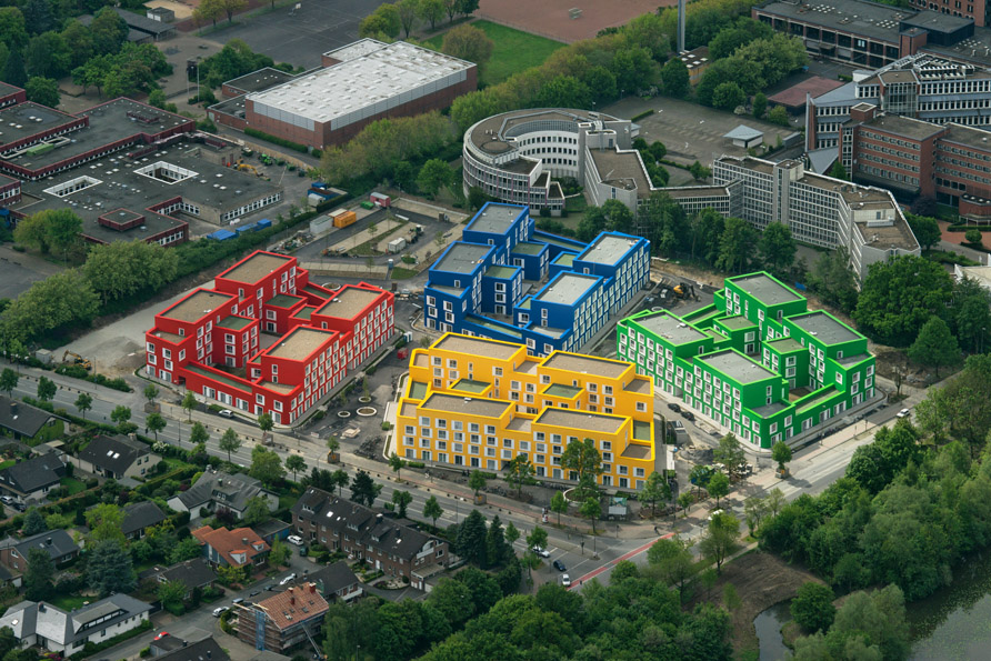 Die bunte Wohnanlage Boeselagerstraße in Münster besteht aus vier ausgebauten Wohnblöcken in vier verschiedenen Farben: kräftigem Rot, Gelb, Blau und Grün. 