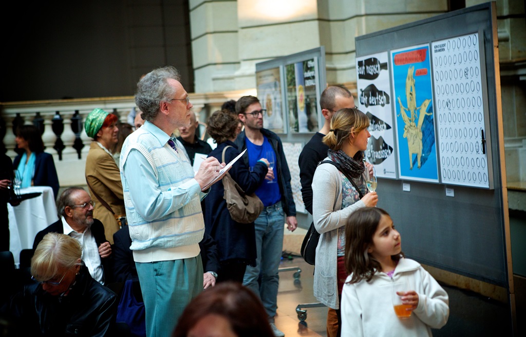 Eine Gruppe von Gästen betrachtet interessiert die Plakate auf der Ausstellung im Museum für Kommunikation.